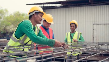 Construction worker is tying the structural steel firmly There is a supervisor to advise and supervise the work closely.